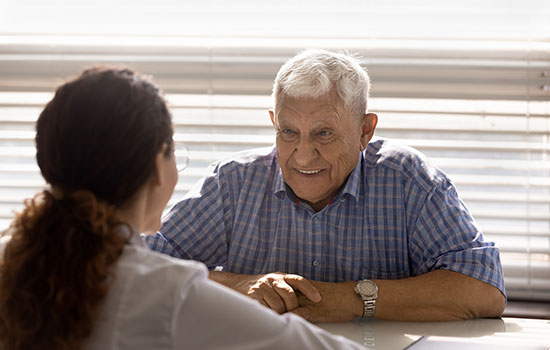 elderly man discussing bill with administrative expert